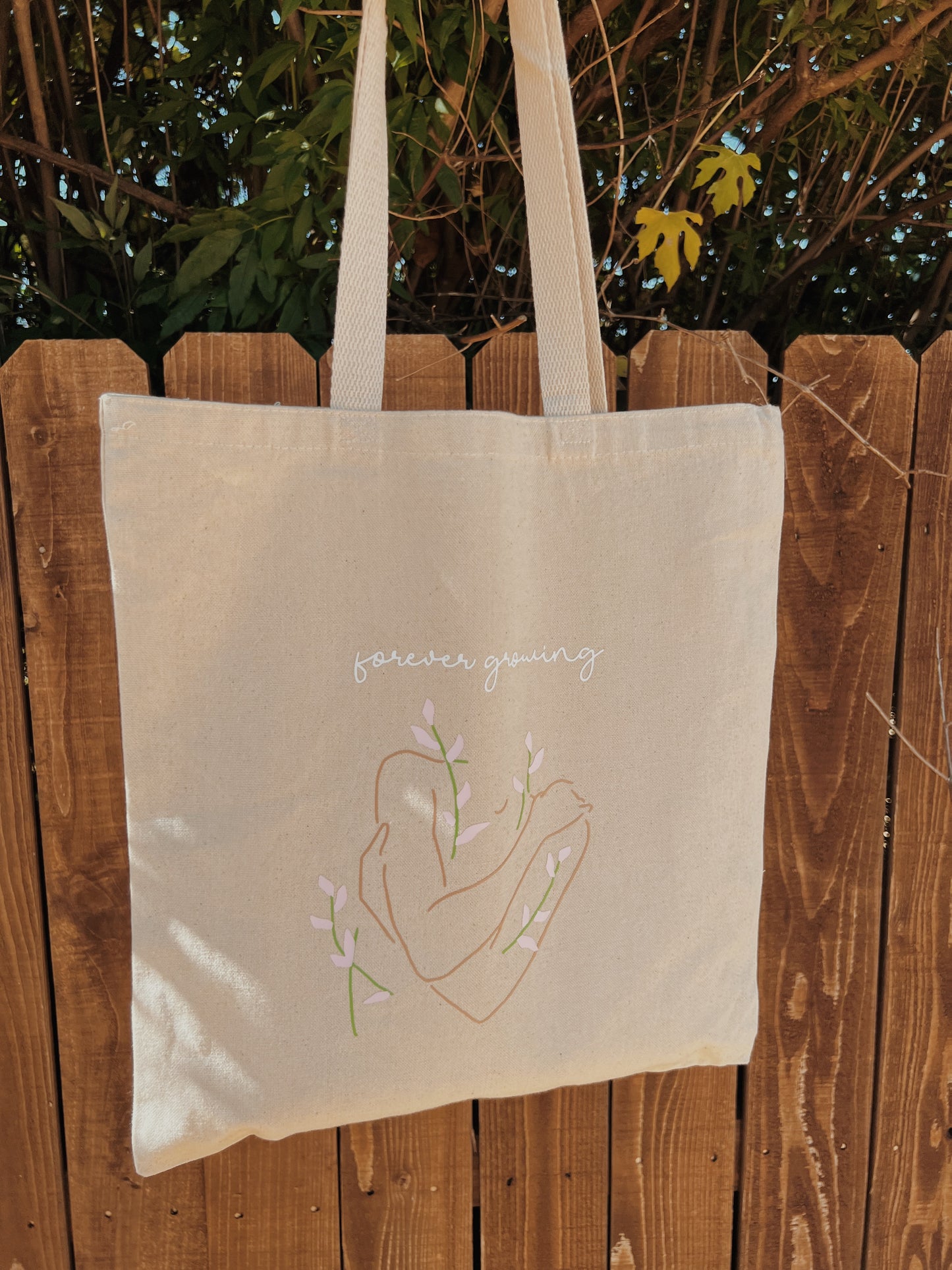 natural tote bag in front of brown fence 