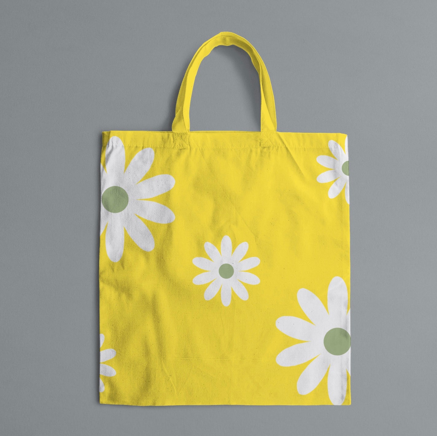 yellow tote bag with white flowers on gray background